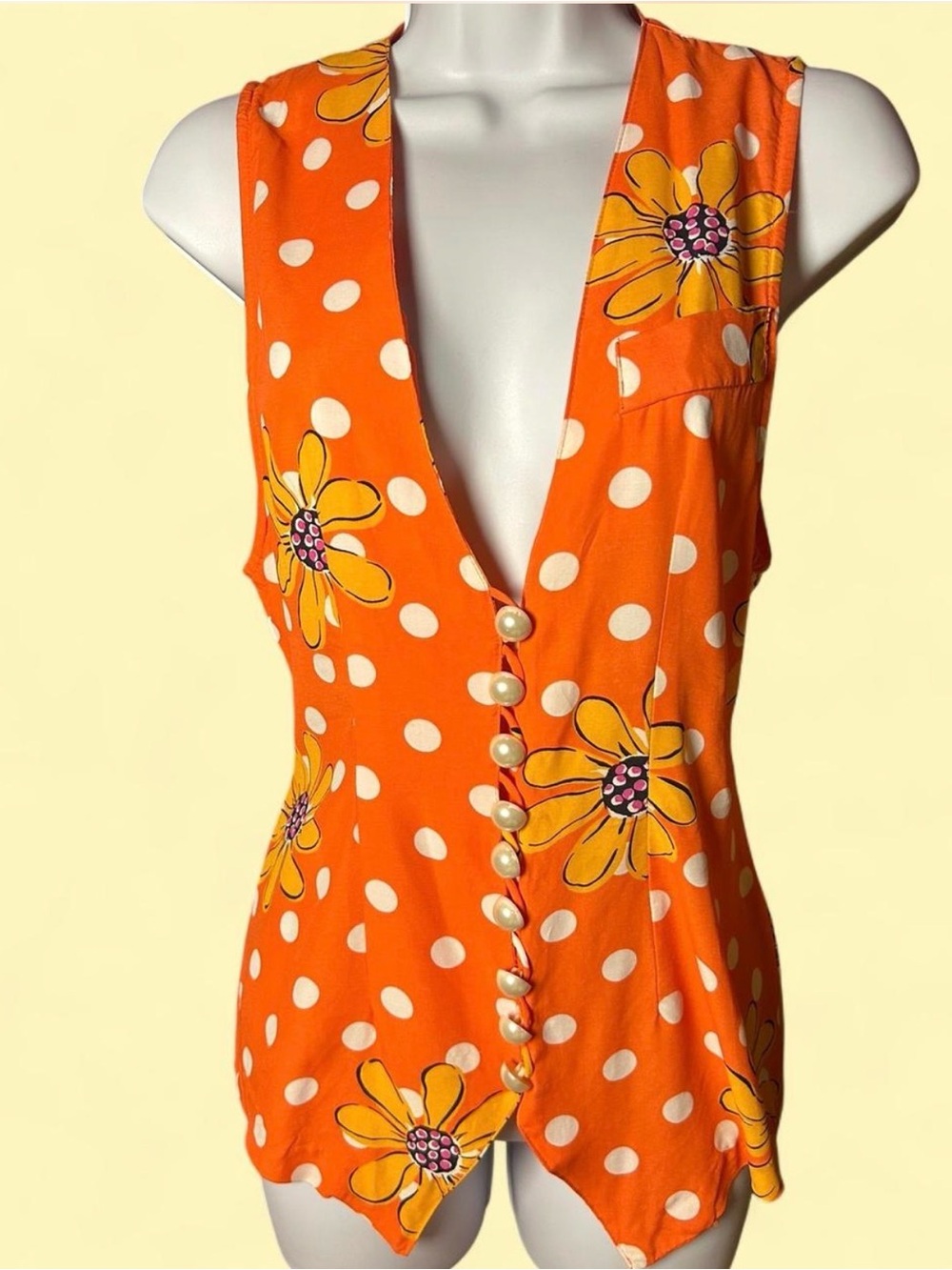 Vintage 1970’s vibrant orange sleeveless vest. Pop print flowers and polka dots